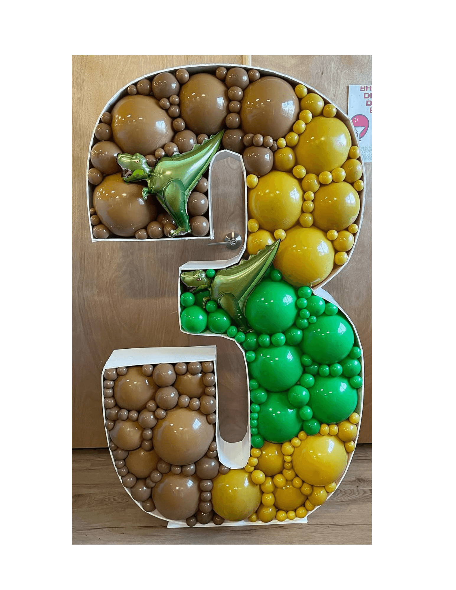 Decorative number '3' made of balloons on a wooden surface